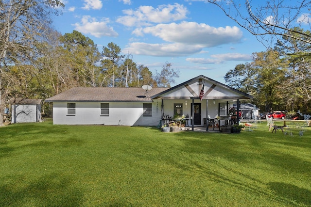 rear view of house featuring covered porch and a lawn