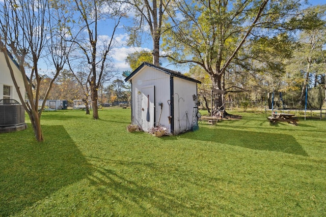 view of yard with central air condition unit, a storage unit, and a trampoline