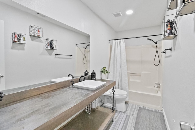 full bathroom featuring sink, shower / bath combination with curtain, and toilet