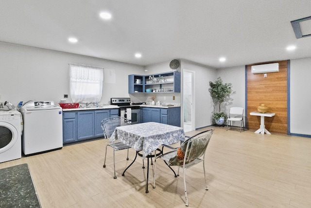 interior space with separate washer and dryer, stainless steel electric range oven, light wood-type flooring, and a wall mounted AC