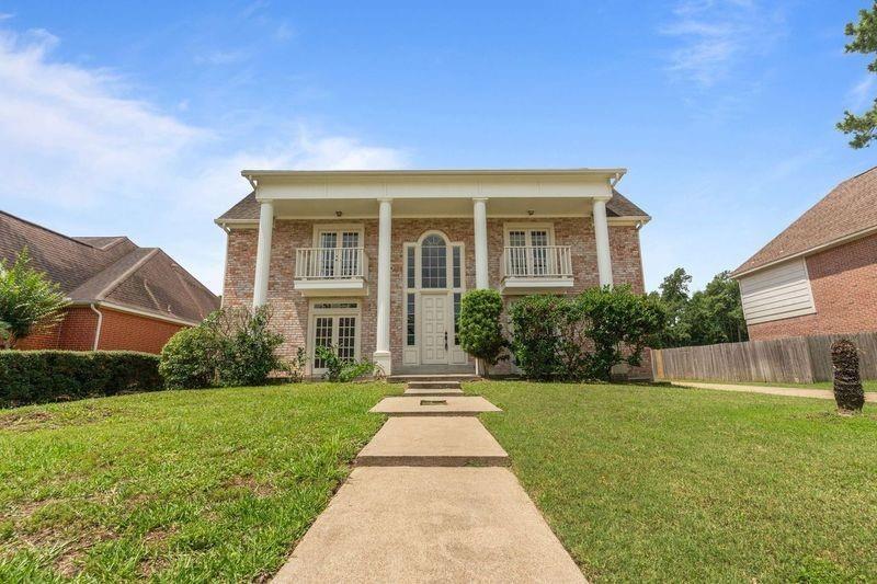 view of front of home featuring a front yard and a balcony