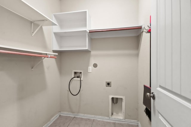 washroom featuring electric dryer hookup, light tile patterned floors, and washer hookup