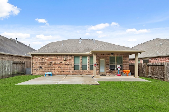 back of house featuring central air condition unit, a patio area, and a lawn