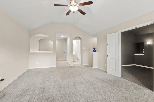 unfurnished living room with light colored carpet, vaulted ceiling, and ceiling fan