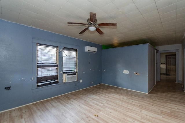 spare room featuring cooling unit, light wood-type flooring, and a wall unit AC