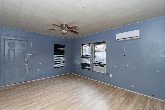 unfurnished room featuring a wall mounted air conditioner, ceiling fan, cooling unit, and wood-type flooring