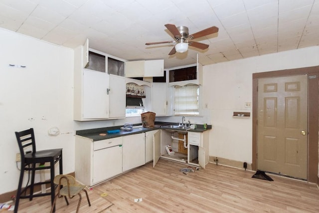 kitchen with ceiling fan, sink, white cabinets, and light wood-type flooring