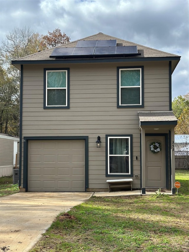 view of front of home with solar panels, a garage, and a front lawn