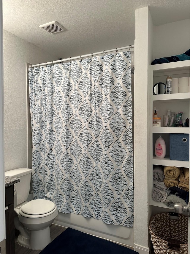 full bathroom with vanity, toilet, a textured ceiling, and shower / tub combo