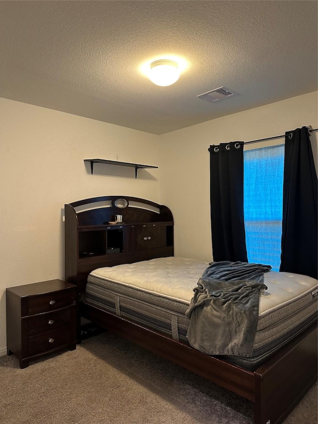 bedroom with carpet flooring and a textured ceiling