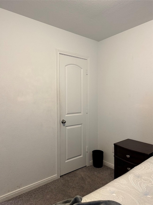 unfurnished bedroom featuring dark carpet