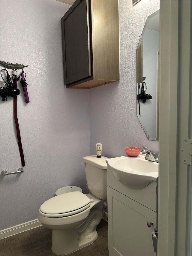 bathroom with vanity, hardwood / wood-style flooring, and toilet