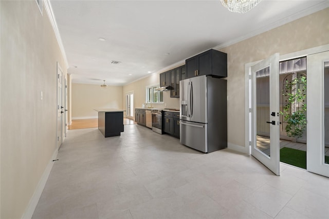 kitchen with appliances with stainless steel finishes, an inviting chandelier, a wealth of natural light, and a kitchen island