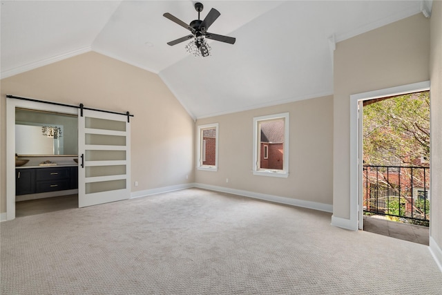 unfurnished bedroom featuring light carpet, a barn door, and multiple windows