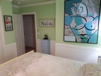 bedroom featuring a wainscoted wall and crown molding