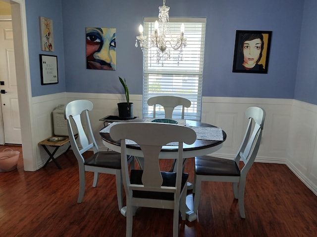 dining area with a wainscoted wall, wood finished floors, and a notable chandelier