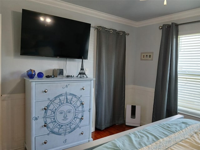 bedroom with crown molding and wood finished floors