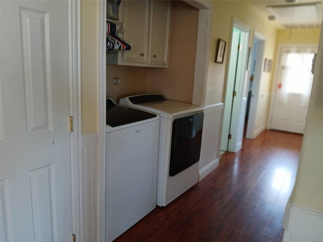 clothes washing area featuring washer and dryer, dark wood-style flooring, and cabinet space