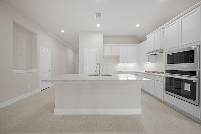 kitchen featuring stainless steel appliances, visible vents, white cabinetry, a sink, and an island with sink