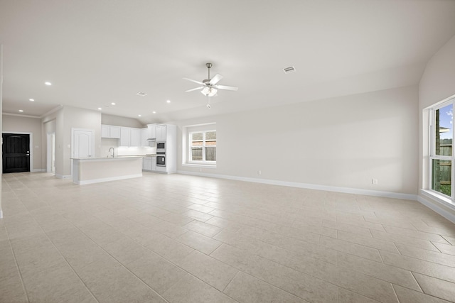 unfurnished living room featuring ceiling fan, visible vents, and baseboards