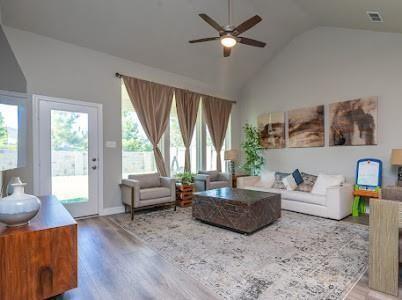 living room featuring hardwood / wood-style floors, ceiling fan, and high vaulted ceiling