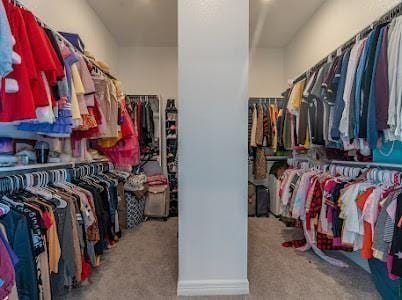 spacious closet featuring light colored carpet