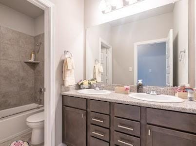 full bathroom with toilet, vanity, and tiled shower / bath