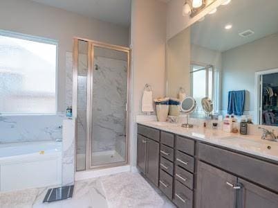 bathroom with vanity and shower with separate bathtub