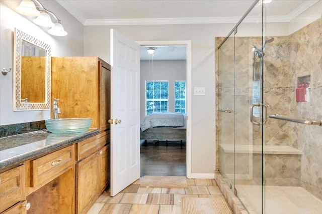 bathroom featuring wood-type flooring, vanity, a shower with shower door, and crown molding