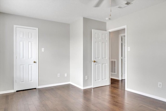 unfurnished room featuring ceiling fan, dark hardwood / wood-style flooring, and a textured ceiling