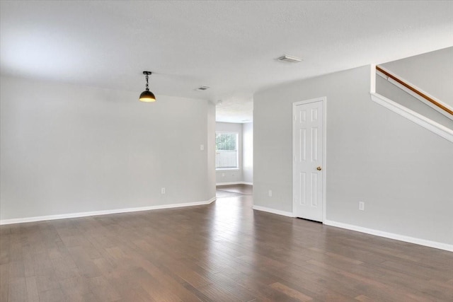 unfurnished room featuring a textured ceiling and dark wood-type flooring