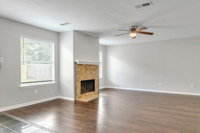 unfurnished living room with ceiling fan, dark hardwood / wood-style flooring, and a textured ceiling