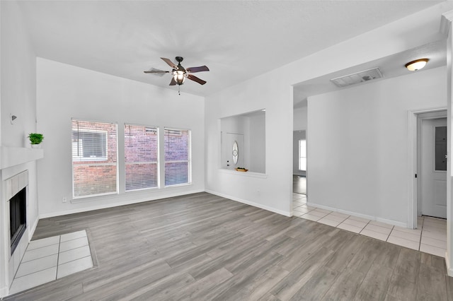 unfurnished living room featuring ceiling fan and light wood-type flooring