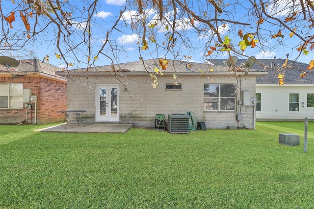 rear view of house featuring a lawn, cooling unit, and a patio area