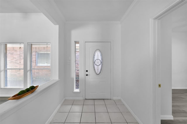 entrance foyer with a wealth of natural light, crown molding, and light tile patterned flooring