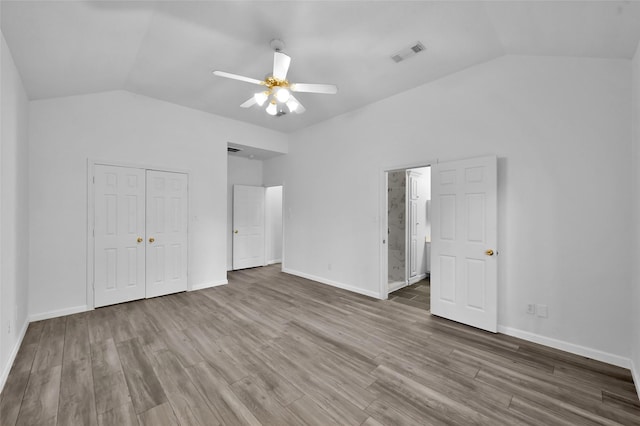 unfurnished bedroom featuring wood-type flooring, a closet, vaulted ceiling, and ceiling fan