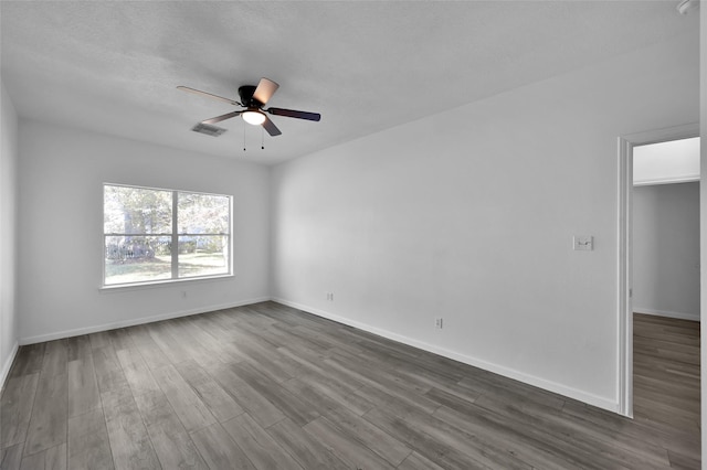 unfurnished room with ceiling fan and dark wood-type flooring