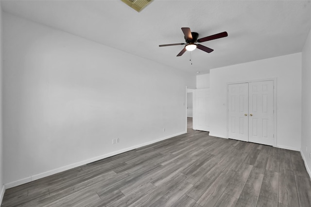 unfurnished bedroom with ceiling fan, a closet, and wood-type flooring