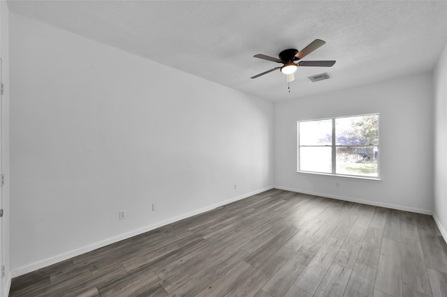 spare room featuring ceiling fan, dark hardwood / wood-style floors, and a textured ceiling