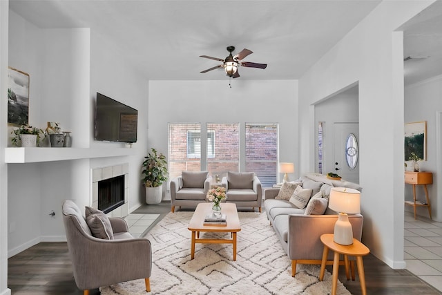 living room with a fireplace, light hardwood / wood-style floors, and ceiling fan