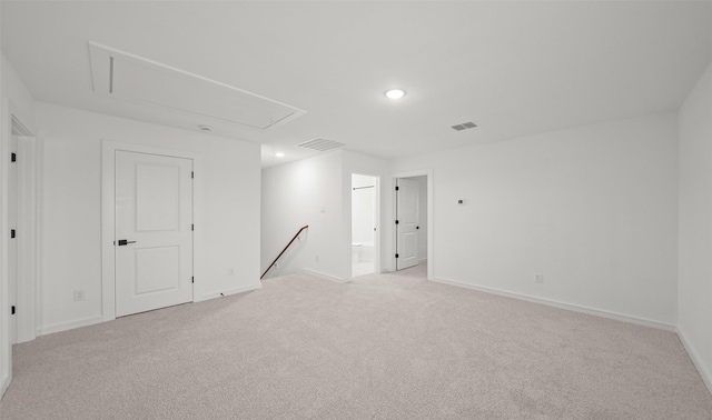 empty room featuring recessed lighting, light colored carpet, visible vents, baseboards, and attic access