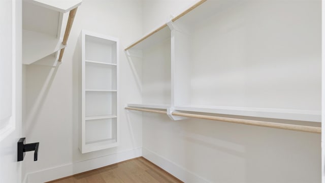 walk in closet with hardwood / wood-style flooring