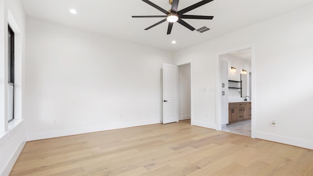 unfurnished bedroom with ensuite bathroom, sink, ceiling fan, and light wood-type flooring