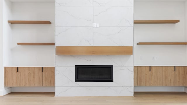 details featuring hardwood / wood-style flooring and a tile fireplace