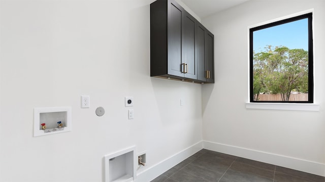 laundry area with cabinets, hookup for an electric dryer, hookup for a gas dryer, hookup for a washing machine, and dark tile patterned flooring