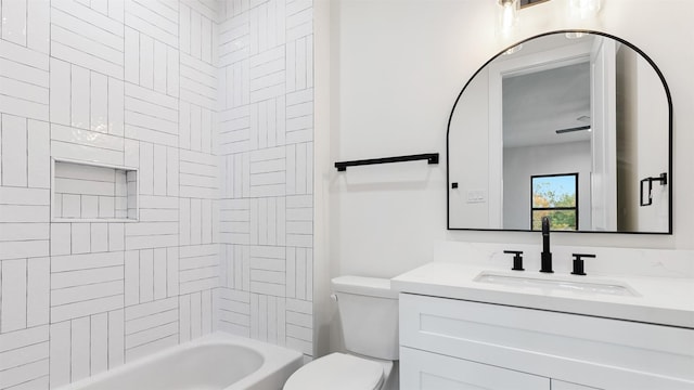 full bathroom featuring tiled shower / bath, vanity, and toilet