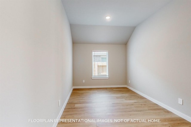 unfurnished room featuring vaulted ceiling and light hardwood / wood-style flooring