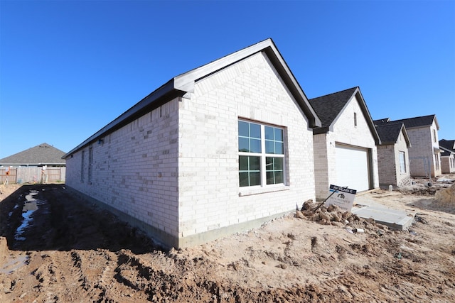 view of property exterior featuring fence and brick siding