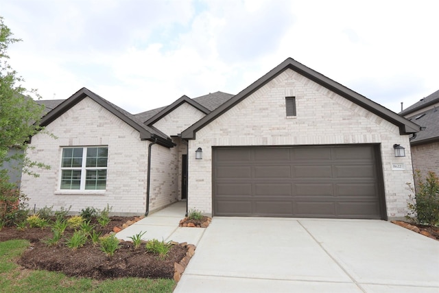 view of front of property featuring an attached garage, brick siding, and concrete driveway