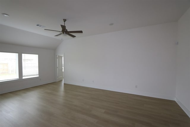 spare room featuring wood finished floors, vaulted ceiling, visible vents, and a ceiling fan
